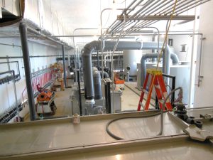 A wide angle picture of an industrial turnkey water treatment system, equipment includes carbon filters, oil-water separator, air stripper, SVE blower and more. Equipment treats VOCs from groundwater.