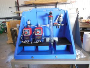 Diaphragm pumps installed inside a containment enclosure for permanganate injection in greensand