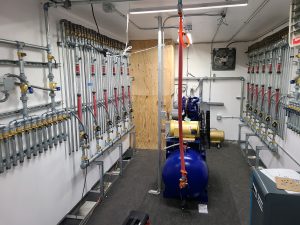 A pre-packaged turnkey water treatment system houses compressors and piping manifolds for air distribution